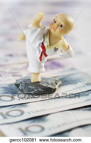 Close-up of a figurine over Chinese currency View Large Photo Image Stock Image - Close-up of a figurine over Chinese currency. Fotosearch