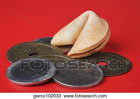 Stock Image - Close-up of Chinese coins with a fortune cookie. Fotosearch