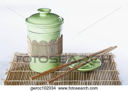 Close-up of chopsticks with a jar on a place mat View Large Photo Image Picture - Close-up of chopsticks with a jar on a place mat. Fotosearch