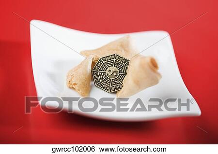Close-up of yin yang symbol on a coin with fortune cookies View Large Photo Image Stock Photograph - Close-up of yin yang symbol on a coin with fortune cookies. Fotosearch