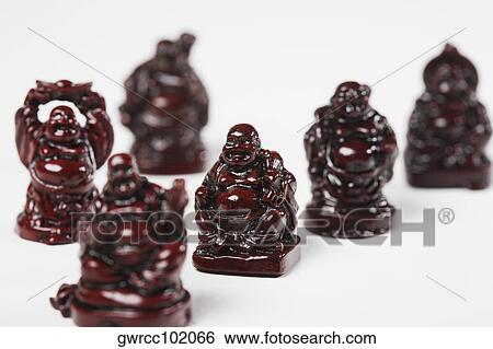 Figurines of Laughing Buddha in a row against white background View Large Photo Image Stock Photograph - Figurines of Laughing Buddha in a row against white background. Fotosearch