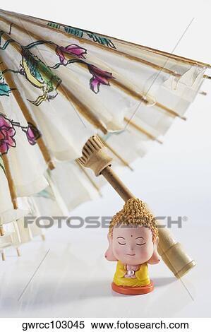 Close-up of a figurine of Buddha with a parasol View Large Photo Image Stock Photography - Close-up of a figurine of Buddha with a parasol. Fotosearch