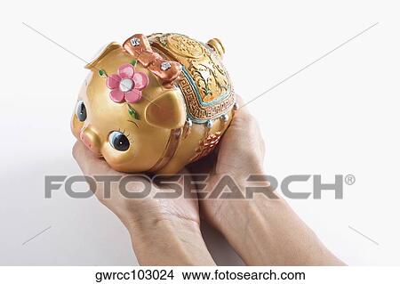 Close-up of a person's hand holding a piggy bank View Large Photo Image Picture - Close-up of a person's hand holding a piggy bank. Fotosearch