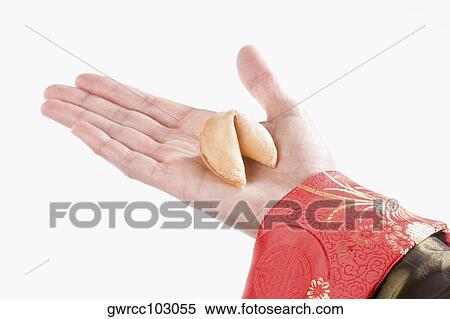Close-up of a person's hand holding a fortune cookie View Large Photo Image Stock Photography - Close-up of a person's hand holding a fortune cookie. Fotosearch