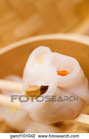 Close-up of a sushi roll being held in chopsticks View Large Photo Image Stock Image - Close-up of a sushi roll being held in chopsticks. Fotosearch