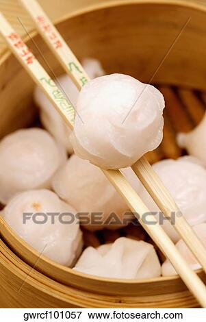 Close-up of Chinese dumplings being held in chopsticks View Large Photo Image Stock Photo - Close-up of Chinese dumplings being held in chopsticks. Fotosearch