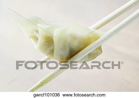Close-up of Chinese dumplings being held in chopsticks View Large Photo Image Stock Photograph - Close-up of Chinese dumplings being held in chopsticks. Fotosearch