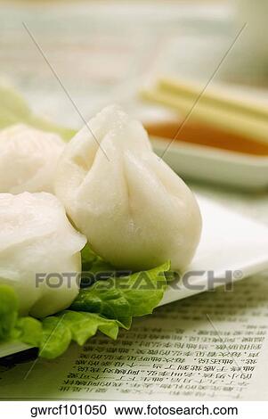Stock Image - Close-up of Chinese dumplings served in a tray. Fotosearch