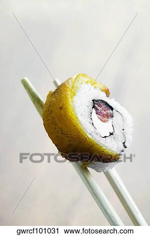 Close-up of sushi being held in chopsticks View Large Photo Image Stock Image - Close-up of sushi being held in chopsticks. Fotosearch