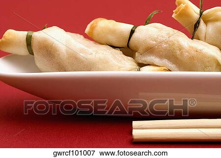 Stock Photo - Close-up of sushi with chopsticks. Fotosearch