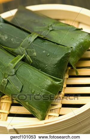Rice dumplings wrapped in banana leaves View Large Photo Image Stock Image - Rice dumplings wrapped in banana leaves. Fotosearch