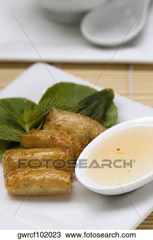 Stock Image - Close-up of spring rolls served in a tray. Fotosearch