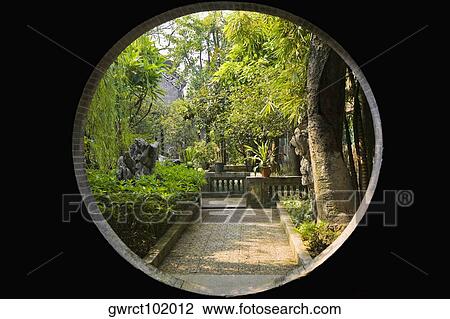 Stock Image - Garden viewed through a window, Yu Yin Shan Fang, Panyu, Guangzhou, Guangdong Province, China. Fotosearch