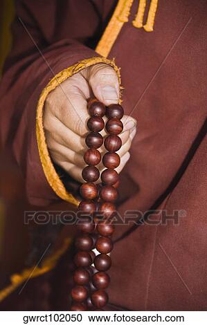 Mid section view of a monk's hand holding prayer beads, Da Zhao Temple, Hohhot, Inner Mongolia, China View Large Photo Image Stock Image - Mid section view of a monk's hand holding prayer beads, Da Zhao Temple, Hohhot, Inner Mongolia, China. Fotosearch