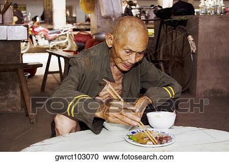 Senior man eating food in a restaurant, Xingping, Yangshuo, Guangxi Province, China View Large Photo Image Stock Image - Senior man eating food in a restaurant, Xingping, Yangshuo, Guangxi Province, China. Fotosearch