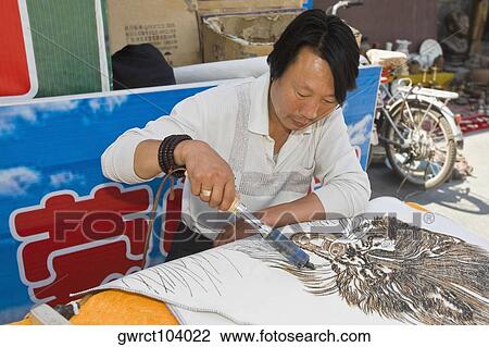 Mature man painting on a piece of cloth with a soldering iron, HohHot, Inner Mongolia, China View Large Photo Image Stock Image - Mature man painting on a piece of cloth with a soldering iron, HohHot, Inner Mongolia, China. Fotosearch