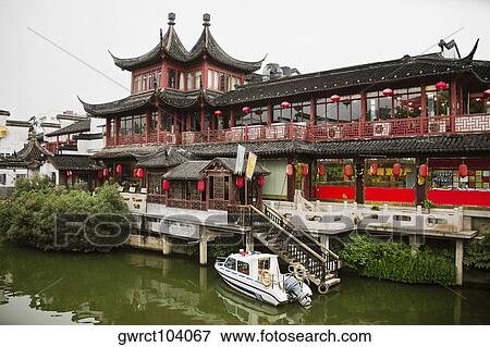 Stock Photo - Motorboat near a building, Nanjing, Jiangsu Province, China. Fotosearch