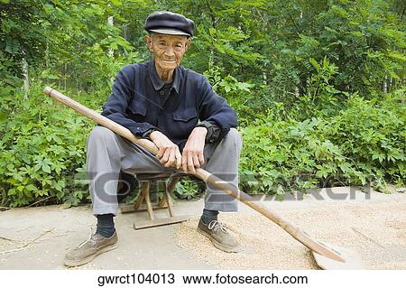 Portrait of a farmer sitting on a stool in a field, Zhigou, Shandong Province, China View Large Photo Image Stock Image - Portrait of a farmer sitting on a stool in a field, Zhigou, Shandong Province, China. Fotosearch