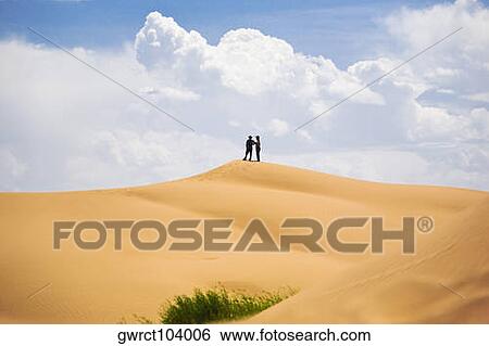 Two people standing on a sand dune, Kubuqi Desert, Inner Mongolia, China View Large Photo Image Stock Photograph - Two people standing on a sand dune, Kubuqi Desert, Inner Mongolia, China. Fotosearch