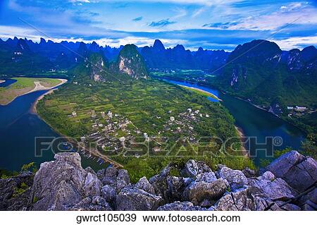 Stock Photo - High angle view of a river passing through mountains, Li River, XingPing, Yangshuo, Guangxi Province, China. Fotosearch