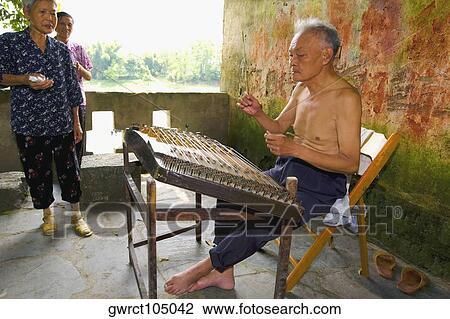 Senior man playing hammered dulcimer with his family standing beside him, Fuli Village, Yangshuo, Guangxi Province, China View Large Photo Image Stock Image - Senior man playing hammered dulcimer with his family standing beside him, Fuli Village, Yangshuo, Guangxi Province, China. Fotosearch