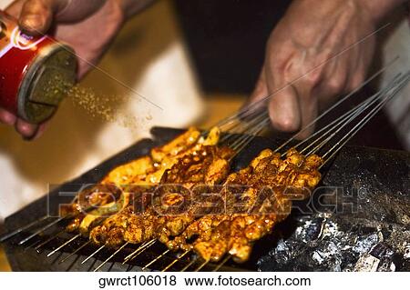 Close-up of a person's hand sprinkling spice on roasted food, Nanjing, Jiangsu Province, China View Large Photo Image Stock Photo - Close-up of a person's hand sprinkling spice on roasted food, Nanjing, Jiangsu Province, China. Fotosearch