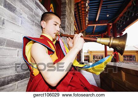 Young man playing horn in a temple, Da Zhao Temple, Hohhot, Inner Mongolia, China View Large Photo Image Stock Photo - Young man playing horn in a temple, Da Zhao Temple, Hohhot, Inner Mongolia, China. Fotosearch