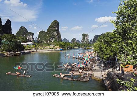 High angle view of wooden rafts at a riverbank with a hill range in the background, Guilin Hills, XingPing, Yangshuo, Guangxi Province, China View Large Photo Image Stock Photograph - High angle view of wooden rafts at a riverbank with a hill range in the background, Guilin Hills, XingPing, Yangshuo, Guangxi Province, China. Fotosearch