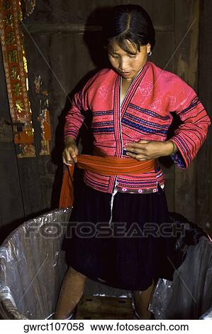 Stock Photo - Mid adult woman putting on clothes in a bathtub, Jinkeng Terraced Field, Guangxi Province, China. Fotosearch