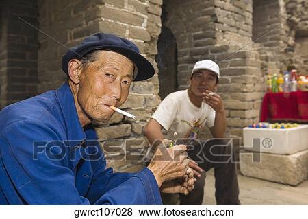 Portrait of a senior man and a mid adult man smoking, Great Wall Of China, Beijing, China View Large Photo Image Stock Photo - Portrait of a senior man and a mid adult man smoking, Great Wall Of China, Beijing, China. Fotosearch