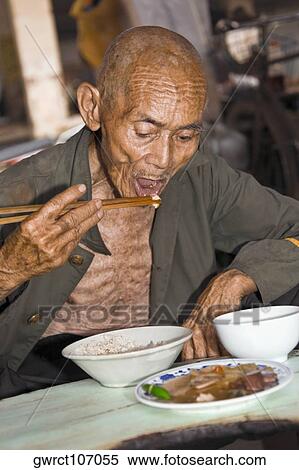 Senior man having food, XingPing, Yangshuo, Guangxi Province, China View Large Photo Image Stock Photography - Senior man having food, XingPing, Yangshuo, Guangxi Province, China. Fotosearch