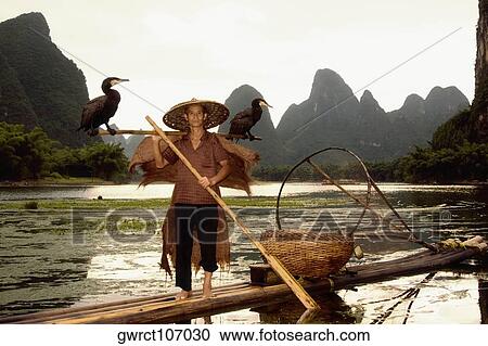 Senior man on a bamboo raft with a hill range in the background, Guilin Hills, XingPing, Yangshuo, Guangxi Province, China View Large Photo Image Stock Image - Senior man on a bamboo raft with a hill range in the background, Guilin Hills, XingPing, Yangshuo, Guangxi Province, China. Fotosearch