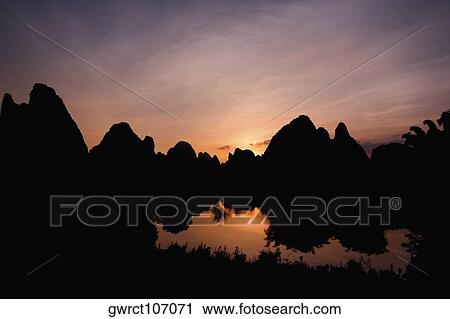 Silhouette of hill ranges at dusk, Guilin Hills, Xingping, Yangshuo, Guangxi Province, China View Large Photo Image Stock Image - Silhouette of hill ranges at dusk, Guilin Hills, Xingping, Yangshuo, Guangxi Province, China. Fotosearch