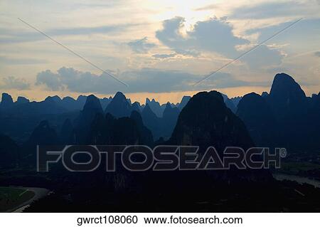 Silhouette of a hill range at dusk, Guilin Hills, XingPing, Yangshuo, Guangxi Province, China View Large Photo Image Stock Image - Silhouette of a hill range at dusk, Guilin Hills, XingPing, Yangshuo, Guangxi Province, China. Fotosearch