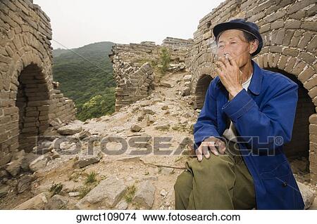 Senior man smoking on a wall, Great Wall Of China, Beijing, China View Large Photo Image Picture - Senior man smoking on a wall, Great Wall Of China, Beijing, China. Fotosearch
