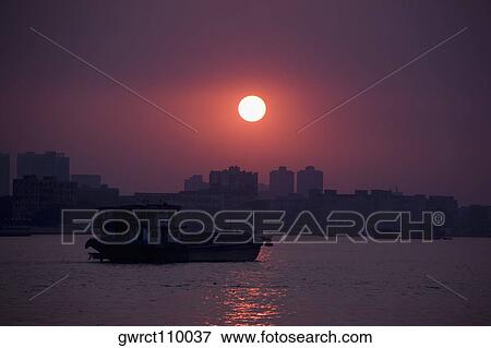 Stock Photo - Silhouette of a boat in a river, Shamian Island, Guangzhou, Guangdong Province, China. Fotosearch