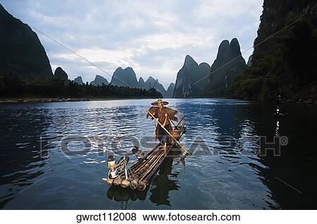 Fisherman standing on a wooden raft in a river, Li River, XingPing, Yangshuo, Guangxi Province, China View Large Photo Image Stock Photo - Fisherman standing on a wooden raft in a river, Li River, XingPing, Yangshuo, Guangxi Province, China. Fotosearch
