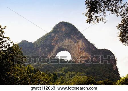 Stock Image - Natural arch formed at a hill, Moon Hill, Yangshuo, Guangxi Province, China. Fotosearch