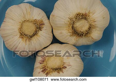 Stock Image - Close-up of three garlic in a bowl. Fotosearch