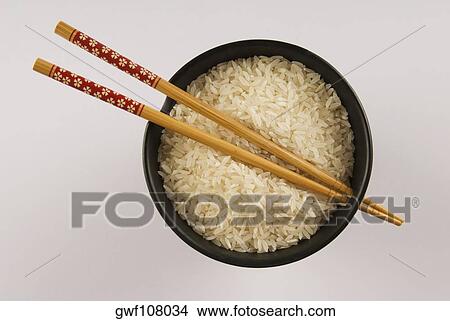 High angle view of white rice and chopsticks in a bowl View Large Photo Image Picture - High angle view of white rice and chopsticks in a bowl. Fotosearch