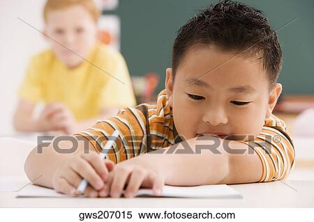 Stock Photography - Close-up of a schoolboy holding a pencil. Fotosearch