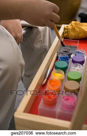 Stock Photograph - Close-up of a student painting in an art class. Fotosearch