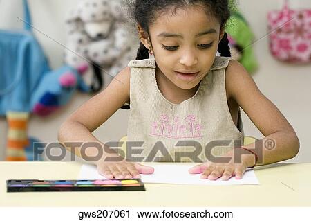 Stock Image - Girl's hands printing on a sheet of paper. Fotosearch