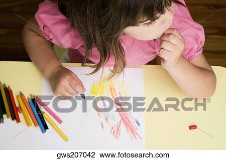 High angle view of a girl drawing on a sheet of paper and thinking View Large Photo Image Stock Image - High angle view of a girl drawing on a sheet of paper and thinking. Fotosearch