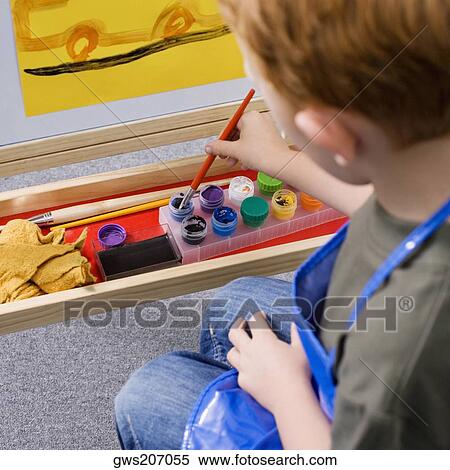 Stock Photography - High angle view of a schoolboy painting in an art class. Fotosearch