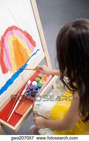 Stock Photo - High angle view of a schoolgirl painting in an art class. Fotosearch