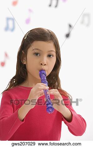 Stock Photo - Portrait of a girl playing a flute in a classroom. Fotosearch