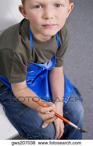 Portrait of a schoolboy holding a paintbrush View Large Photo Image Stock Photo - Portrait of a schoolboy holding a paintbrush. Fotosearch