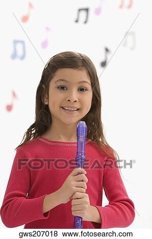 Stock Photo - Portrait of a schoolgirl holding a flute and smiling. Fotosearch