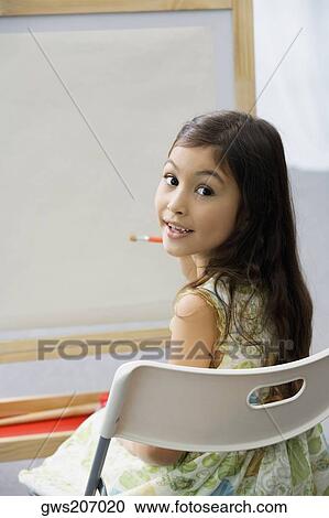 Portrait of a schoolgirl sitting on a chair and painting in an art class View Large Photo Image Stock Image - Portrait of a schoolgirl sitting on a chair and painting in an art class. Fotosearch